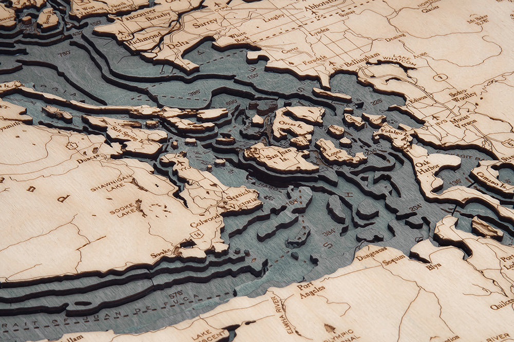 Close-up of the grey-finish Salish Sea wood map showing the islands and depth layers